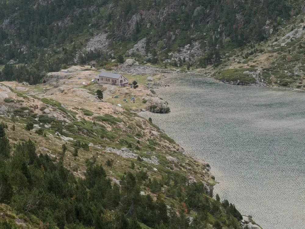 Vue sur le lac d'Estom et son refuge au bord avec l'espace de bivouac