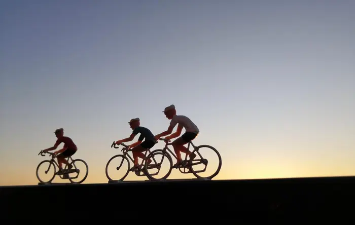 Petits cyclises en plastique faisant la course dans le soleil couchant