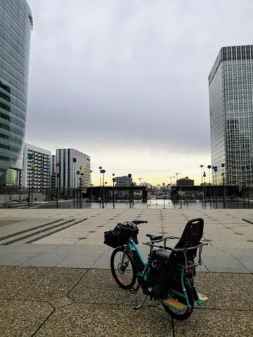 Yuba modèle Boda Boda vert bleu sur le parvis de la Défense à Courbevoie. Paris en fond
