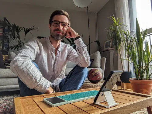 Geoffrey Arduini souriant assis au sol dans la lumière du soleil levant