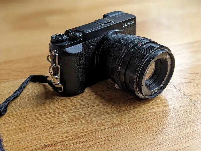 Mon appareil photo LUMIX GX80 avec un objectif manuel posés sur une table