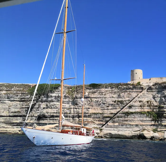 Voilier longeant les falaises de Bonifacio en Corse