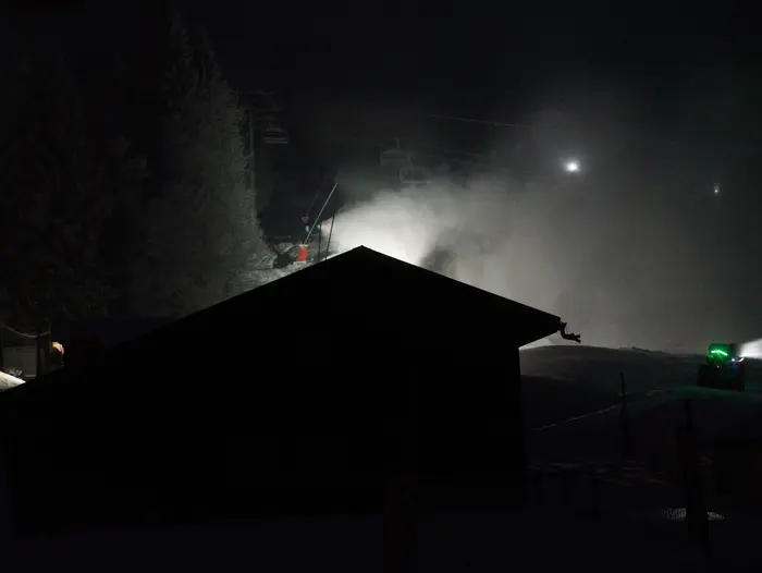 Vue de nuit des projections de canons à neige sur les pistes